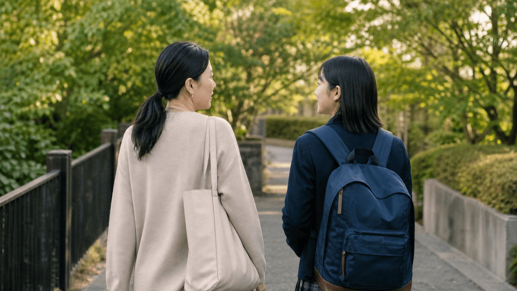 緑の多い道を保護者と思春期の子どもが並んで歩いている場面