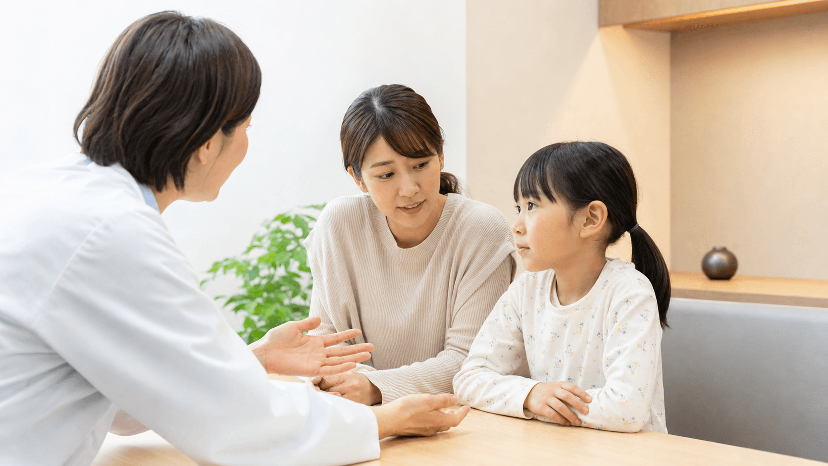 診察室で保護者と子どもが医師からアレルギー対応の説明を聞いている場面