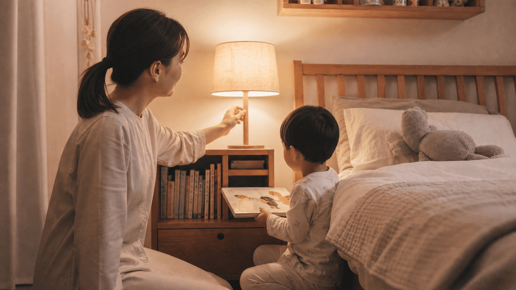 寝室で保護者と子どもが就寝前の絵本を片付けている場面